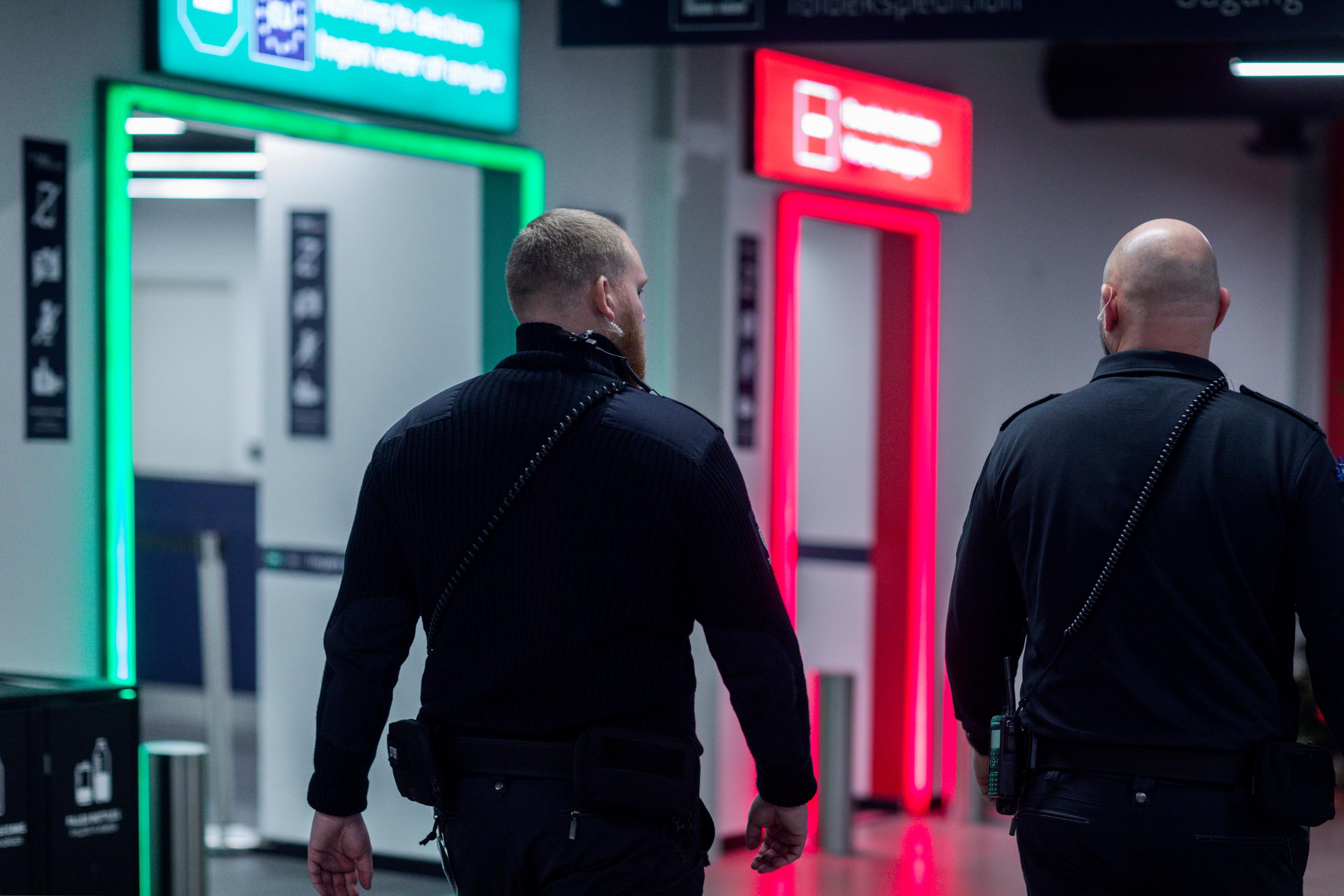 To toldere ved grøn og rød kanal i lufthavn