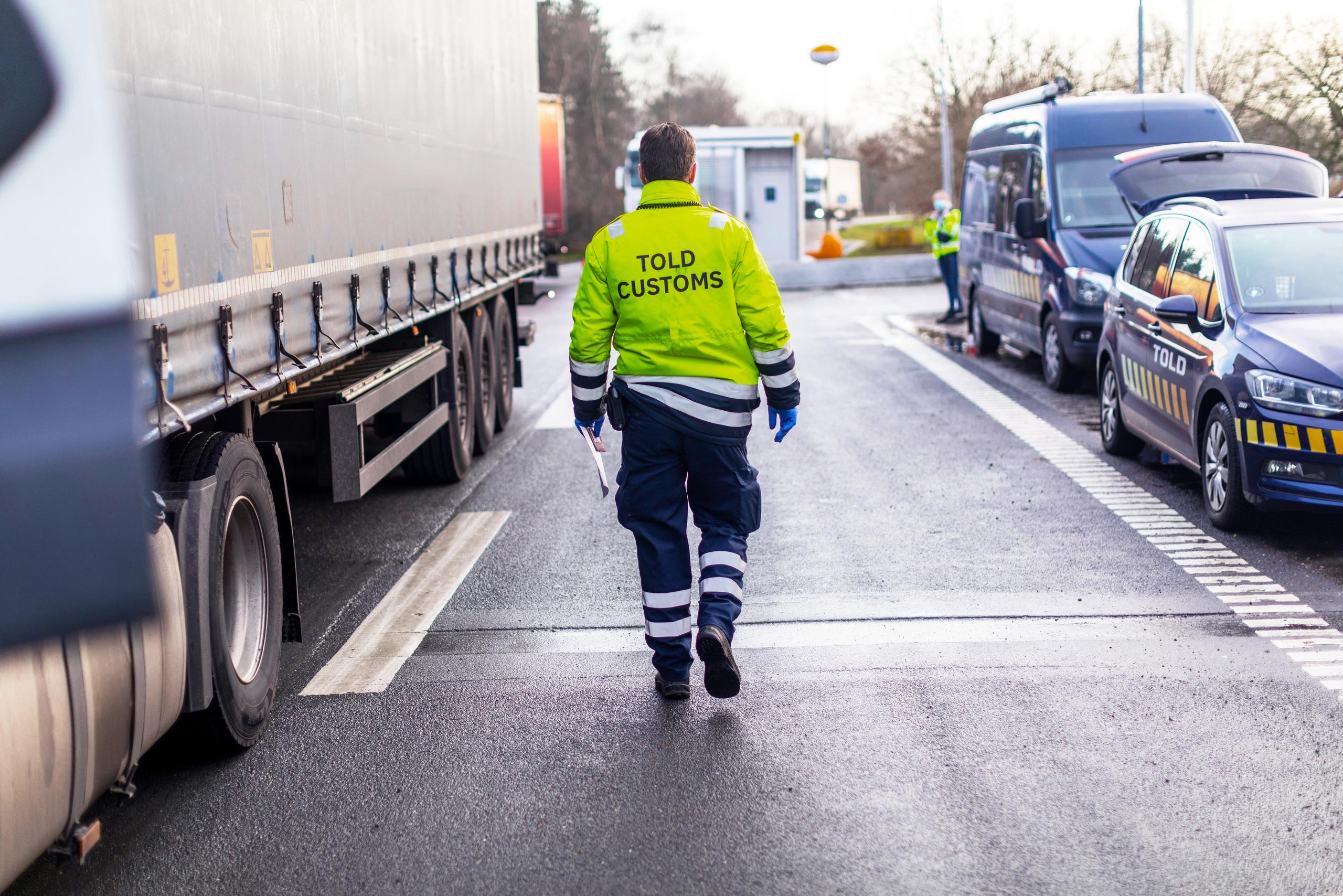 Tolder med lastbil på venstre side og toldbiler på højre side